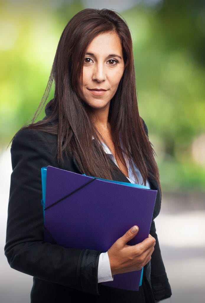 Na zdjęciu widać młodą kobietę z dokumentami w ręku wyglądającą na prawniczkę która dopytujeo o odszkodowania gdańsk.