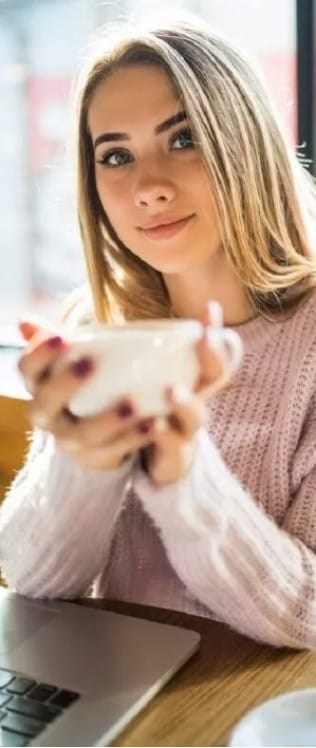 na zdjęciu mloda kobiwta trzyma parującą filiżankę z herbatą i czeka na regulamin świadczenia usług drogą elektroniczną